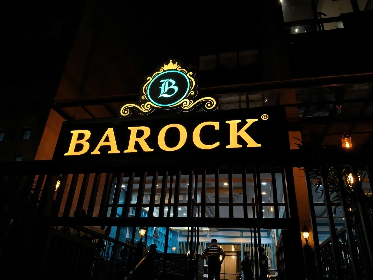 Illuminated BAROCK CAFE entrance and signage at night